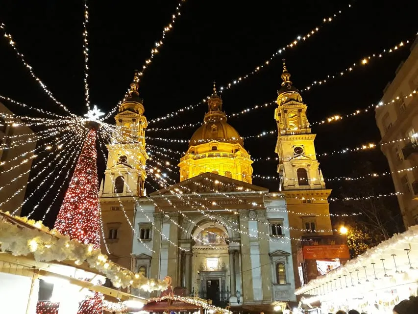 The Parliament lit at night by the Danube on a Budapest Christmas market tour by tram