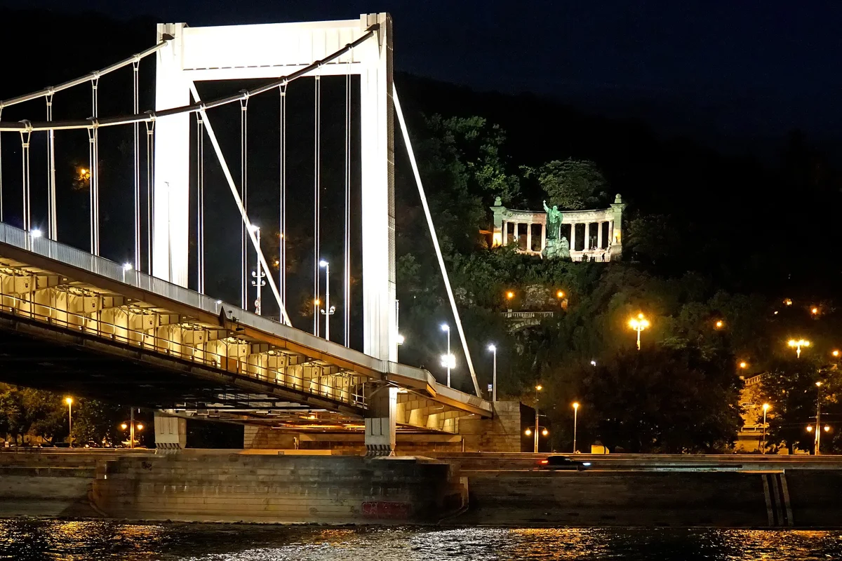 Elizabeth Bridge lit at night beside the dock of the Budapest mulled wine cruise