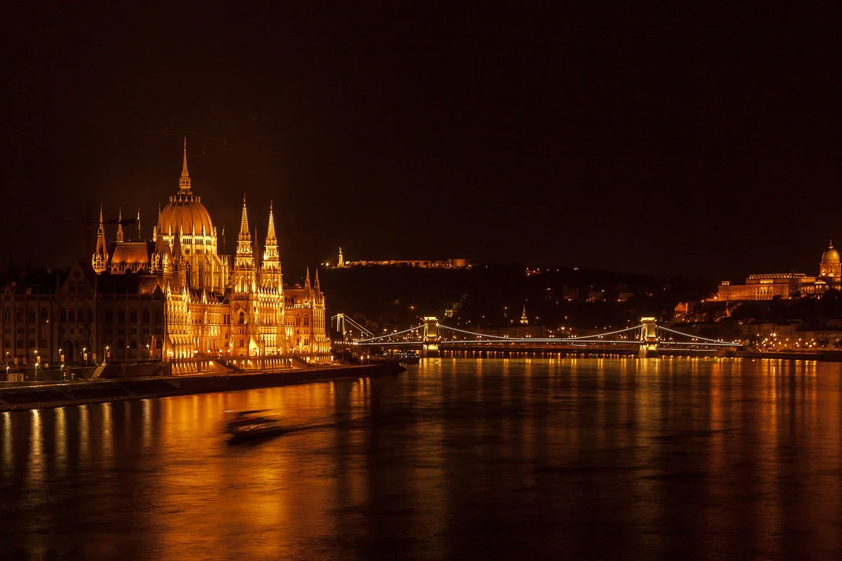 The Parliament reflected in the Danube at night, the headline sight of a Budapest mulled wine cruise